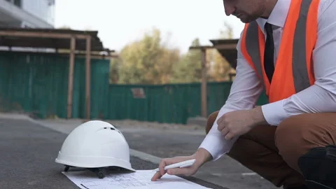 A young foreman at a construction site is looking at drawings Stock Footage 124646233