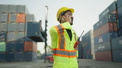 Young foreman engineer talking on smartphone while working at container terminal Video stock 263803037
