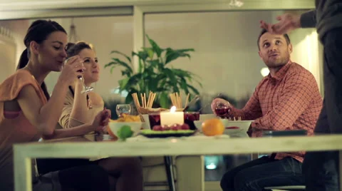 Young four friends by the dinner table at home HD Stock Footage 37221987