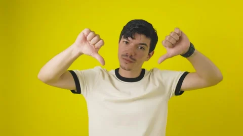 Young freckled man making a gesture of disgust with thumbs down on a yellow.. Stock Footage 311655219