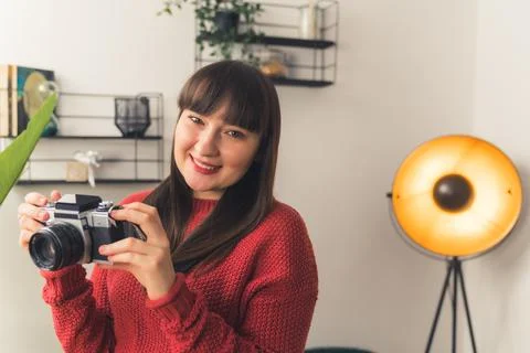 Young freelance creator at her studio. Cheerful caucasian woman holding her Stock Photos
