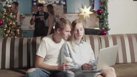 Young Freelancer Couple Work Online While Friends Have Fun Celebrate Christmas. 動画素材 142658786