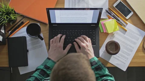 Young freelancer drinking coffee and working with his laptop from home Stock Footage 142873682