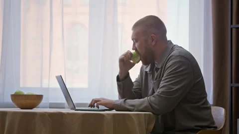 Young Freelancer Eating Green Apple while Working from Home Stock Footage 315861767