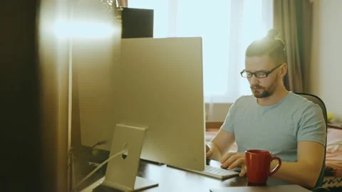 A young freelancer man using a computer learns to work online at home. Stock Footage 237116741