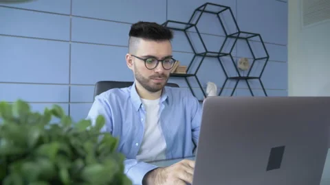 Young freelancer man working on computer at home. Casual concentrated Stock Footage 147844108