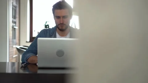 Young freelancer man working on laptop, developing project while working at home Stock Footage 155332067