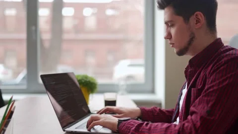 Young freelancer man working with laptop at bright spacious coworking alone Stock Footage 217733660