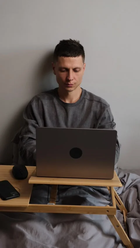 Young freelancer opening laptop in bed and starting work at home, remote work Stock Footage 314744575