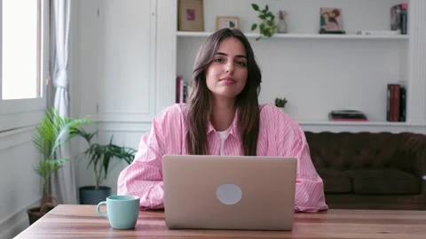Young freelancer smiling at the camera working remotely from home Stock Footage 335588228