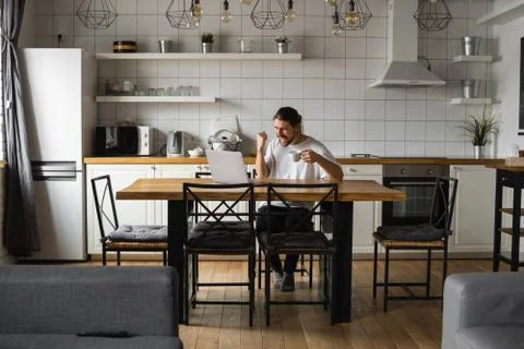 Young freelancer succeed with project working from home. Excited glad young Stock Photos