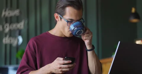 Young freelancer using smartphone and laptop computer in cafe.Freelance concept 스톡 동영상 164258004