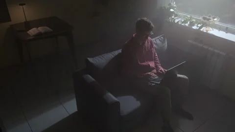 Young freelancer working on laptop in dark room, evening lifestyle. Stock Footage 318651601