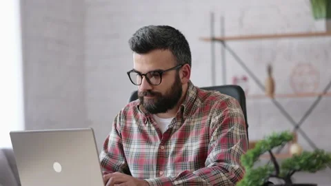 Young freelancer working with laptop sitting at home. Texting messages, browsing Stock Footage 164533748