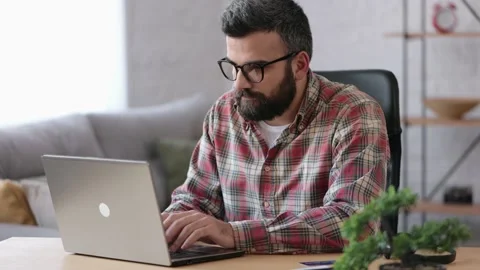 Young freelancer working with laptop sitting at home. Texting messages, browsing Stock Footage 181505755