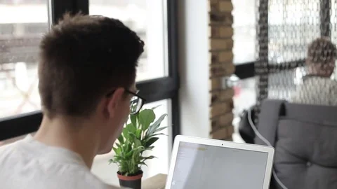 Young freelancer working on a macbook in cafe Stock Footage 74855365
