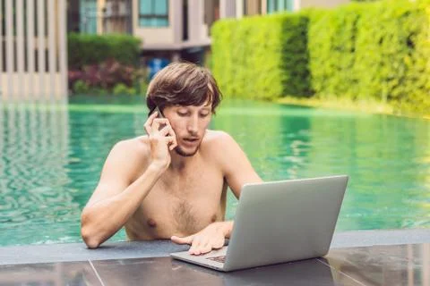 Young freelancer working on vacation next to the swimming pool Stock Photos