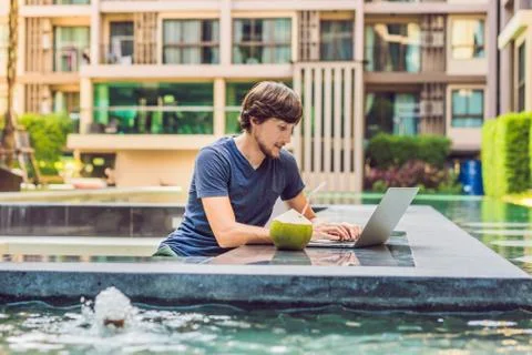 Young freelancer working on vacation next to the swimming pool Stockfoto's