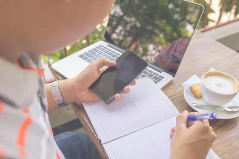 Young freelancer writing into the notes Stock Photos