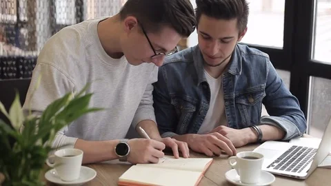 Young freelancers using notebook in the cafe for his work or plans Stock Footage 74855493
