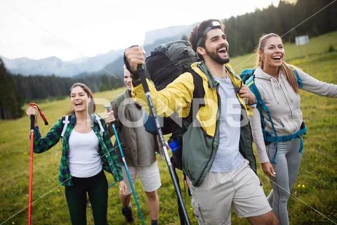 Young friends on a country walk. Group of people hiking through countryside Stock Photos