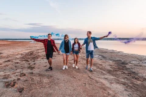 Young friends running with hand flare or fusee Stock Photos