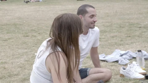 Young Friends Sitting on Grass and Chatting in Park Stock Footage 344616943