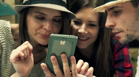 Young friends with smartphone talking while sitting in cafe  HD Stock Footage 51249650