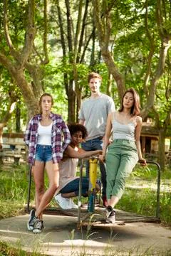Young friends standing on old platform of merry-go-round Stock Photos