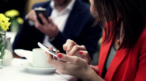 Young friends using smartphone while sitting in cafe in city HD Stock Footage 51779619