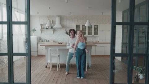 Young full-length couple dancing together in cozy spacious domestic kitchen Stock Footage 156496873