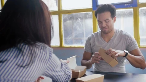 Young funny couple spend lunchtime together at cozy loft, tasting food service Stock Footage 105756331