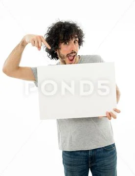 Young funny man holding blank board for advertisement. Millennial men pointin Stock Photos