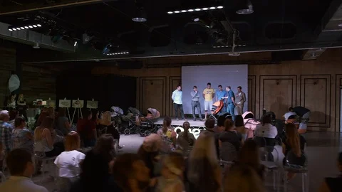 Young future dads participate in a contest for folding and unfolding a stroller Stock Footage 114374541