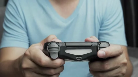 The young game player's hands control the joystick playing on the screen 库存影片 334653462