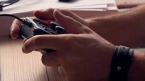 The young game player's hands control the joystick playing on the screen 库存影片 334653619