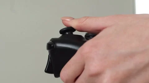 The young game player's hands control the keys of the joystick playing on the 库存影片 334653777