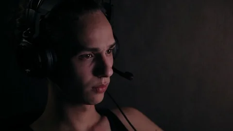 Young gamer in headpsones using computer at home at night 库存影片 99051096