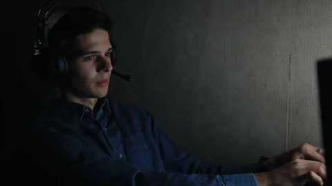Young gamer in headpsones using computer at home at night Video stock 99051147