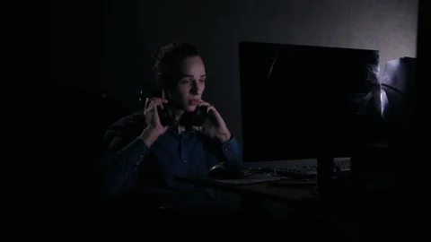 Young gamer in headpsones using computer at home at night Video stock 99051297