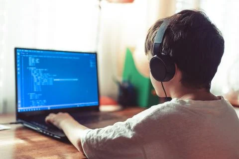 Young geek boy coding on laptop at home Stock Photos