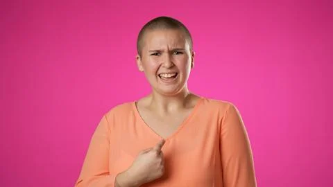 Young gender fluid non binary woman 20s look camera point fingers herself ask Stock Photos