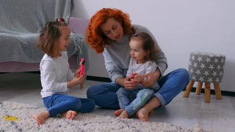 A young ginger mother playing with her two daughters in the house. Vidéo 129339913