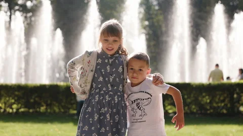 Young girl and boy stand side by side, gradually embracing each other with Video stock 285438053