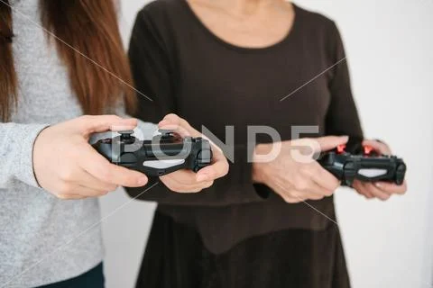 A young girl and an elderly woman play together in a video game. Joint pastime Stock Photos