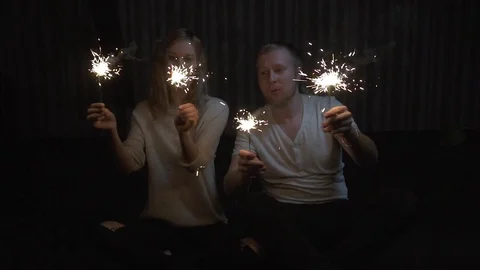 Young girl and guy holding sparklers and smiling. slow motion Stock Footage