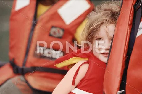 Young girl and parent wearing life-jackets Stock Photos