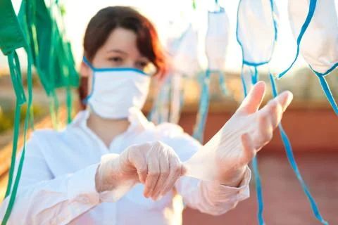 Young girl assistant cleaning masks in these days of pandemic. Stock Photos