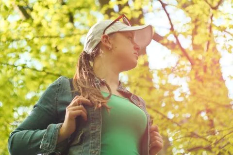 Young girl with a backpack on a tree background Stock Photos