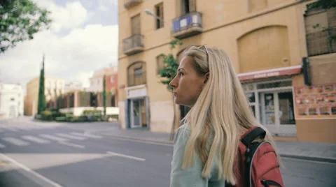 Young girl with backpack walk through the streets in slow motion Vídeos de archivo 64150420